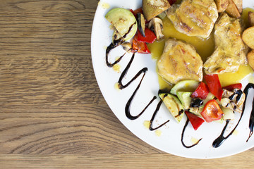 Grilled chicken breast with vegetables and sauce on a plate. Traditional cuisine. Grill kitchen.
