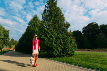 Happy young woman on summer day. Beautiful girl in pink jacket a