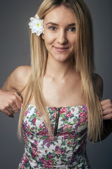 Portrait of a beautiful and gentle blonde girl in the studio on a blue background in the dress, the concept of beauty and health