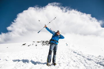 Backpacker in the mountains pretends to shoot arrows on the example of sticks for Nordic walking