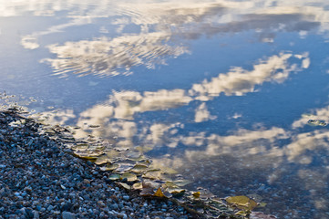 Reflection of a sky with clouds on a lake beach surface in Belgrade, Serbia