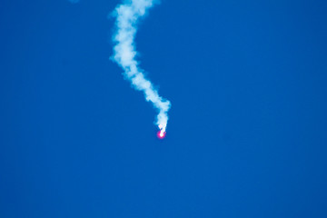 An emergency red rocket in the blue sky in an exercise
