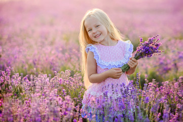 Beautiful girl in a field of lavender on sunset. Beautiful girl in amazing dress walk on the field of lavender.