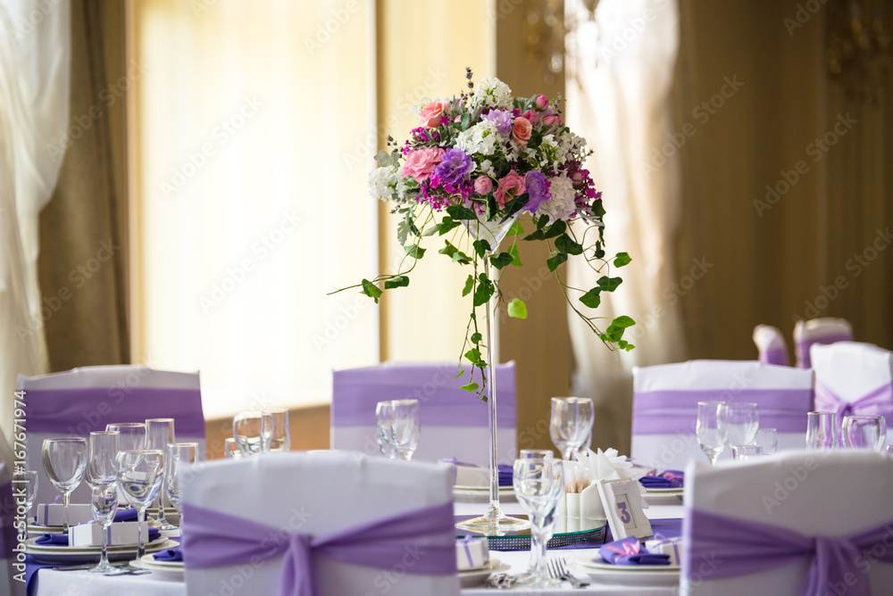 Wall mural vase and floral composition on the wedding served table in a restaurant