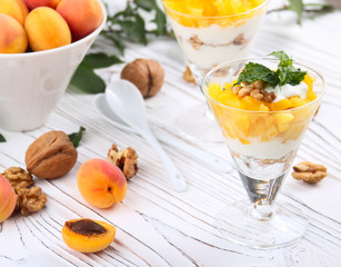Healthy breakfast. Oat granola with yoghurt, apricot on a light wooden background