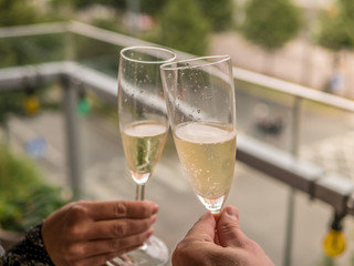 Hands Man and woman on balcony with glasses of champagne