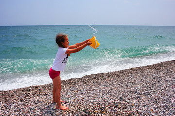 Little girl playing on the beach. 