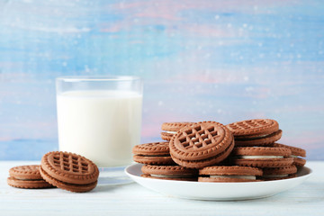 Chocolate cookies with glass of milk on wooden table