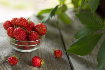 fresh strawberries in a glass bowl on a table in a gazebo