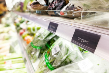 Organic food signage on modern supermarket vegetable aisle
