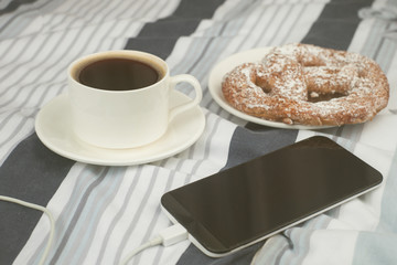 good morning - breakfast with fresh bakey, cup of coffee and a phone in bed