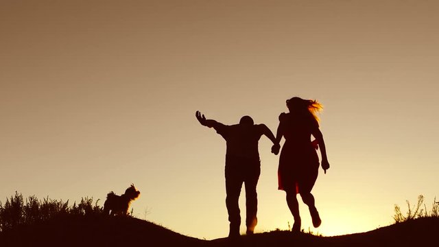 Man and woman couple in love silhouette jumping in slow motion video. Man and woman joy running sunlight and jumping on silhouette nature