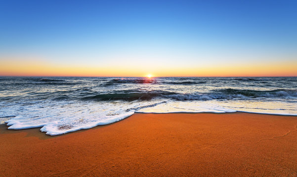 Majestic ocean sunset with a breaking wave. © vrstudio
