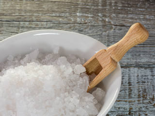 Wooden spoon in sea salt. The crystals of sea salt close up.