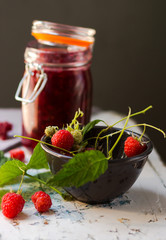 Homemade jam with raspberry on the wooden table.