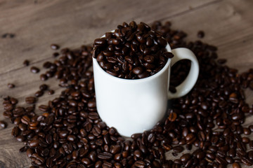 Coffee mug filled and surrounded by coffee beans