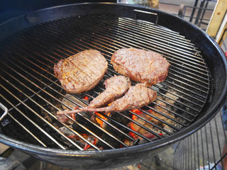 Pieces of cooked steaks on picnic barbecue grill oven waiting to be served.