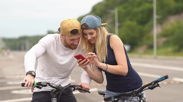 Young couple of cyclists plans a new route.