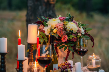 Obraz na płótnie Canvas Wedding bouquet with glasses, vine, candles and fruit outdoor.