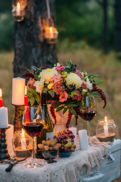 Wedding decor with  glasses, flowers, vases, candles and fruit on a ancient suitcase.