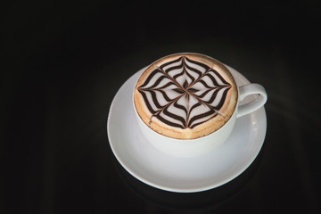 white cup of coffee on black background