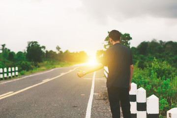 Man hitchhiking on roadside.