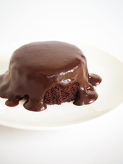 Chocolate cake with chocolate fudge. Served on white plate over white background. Favorite cake for chocolate lover.