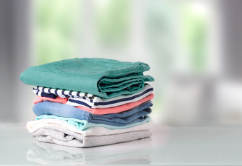 Stack colorful cotton clothes on table empty space background.