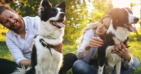 Beautiful couple cuddling and walking dogs outdoors - Powered by Adobe