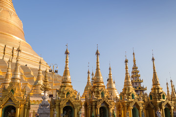 Fototapeta premium Many small pagodas in front of the Shwedagon Pagoda in Yangon, Myanmar on a sunny day.