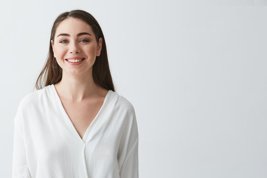 Portrait of happy beautiful young businesswoman smiling looking at camera over white background.