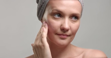 woman puts a cream on facer closeup. 30s woman