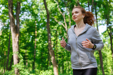 Woman listening music during running in park