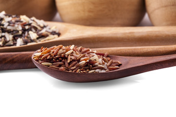 red rice in a wooden spoon isolated on white background
