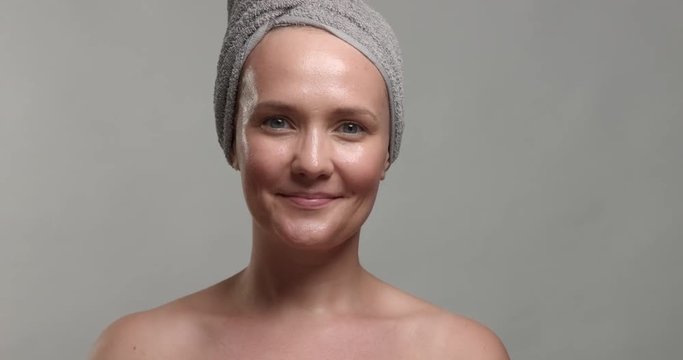 30's woman takes off a facial sheet mask and looking at camera smiling
