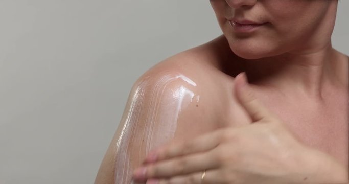 woman's shoulder makes a massage with a cream