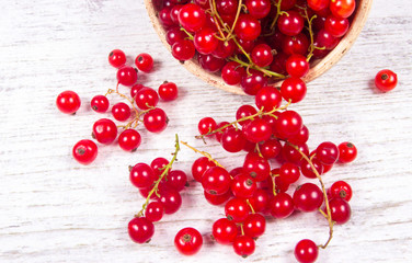 Fresh ripe red currants on rustic wood background.