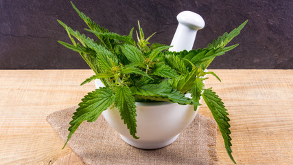 Fresh nettle on a wooden table. The source of vitamins. herbal medicine.