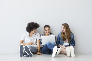 Young people sitting and talking with a computer