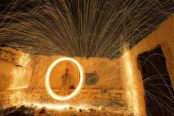 Fototapeta premium Light painting in abandon house with spinning steel wool making fire