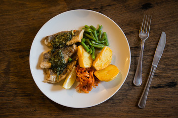 fish and chips plate with vegetables and lemon in a restaurant
