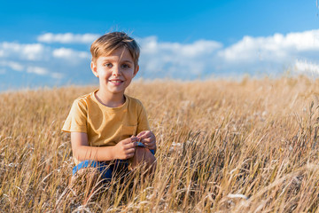 Cheerful boy playing on meadow