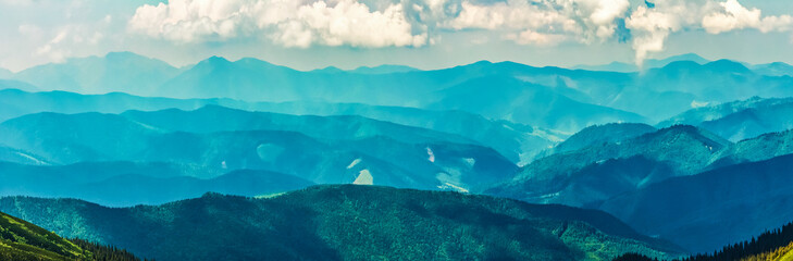 Fototapety  Panoramiczny widok na niebo i grzbiety górskie ze szczytu góry w słoneczny letni dzień