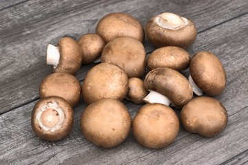 Fresh brown mushrooms on a wooden background.