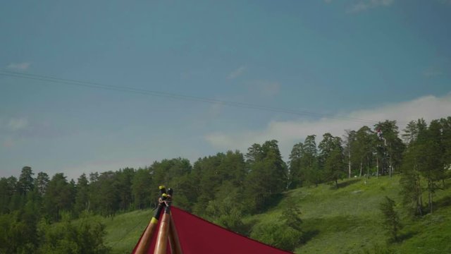 Far away view of man riding zip line in mountains