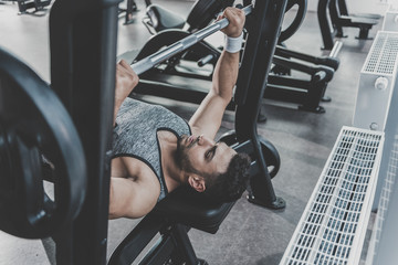 Serene man taking exercise in modern gym