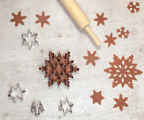 Gingerbread dough and the metallic snowflake on white table, top view, cooking background