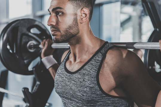 Orderly Unshaven Male Squatting With Barbell