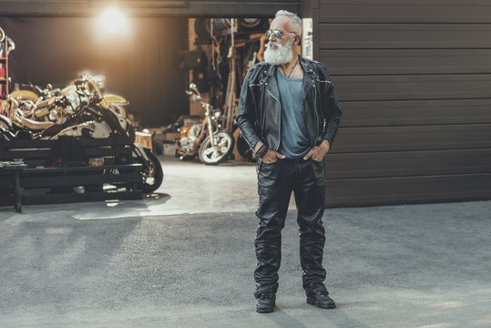 Cool elderly man standing afore building