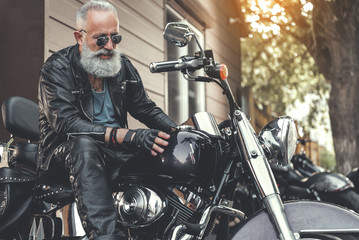 Fototapeta na wymiar Interested old man checking motorbike